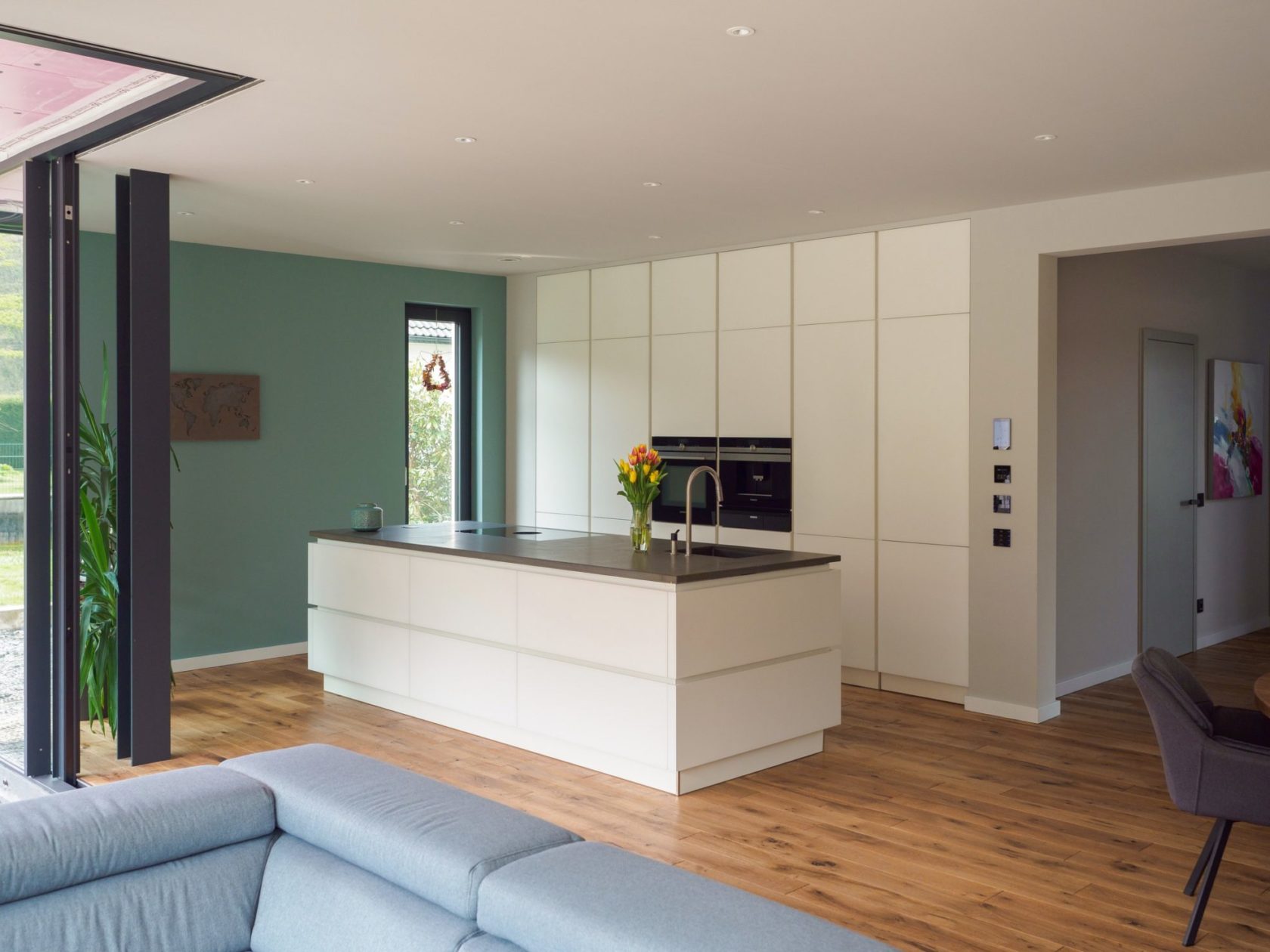 Grifflose Wohnkueche Grosser Kochinsel Matt Weiss Grauwacke Arbeitsplatte Siemens Einbaugeraete Bora Muldenluefter Schrankwand Stauraum 22