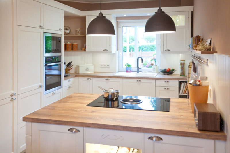 Moderne Landhausküche in weiß von Häcker Küchen mit Kochinsel, BORA